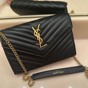 Cassandre Envelope Chain wallet in black grained leather with gold hardware.